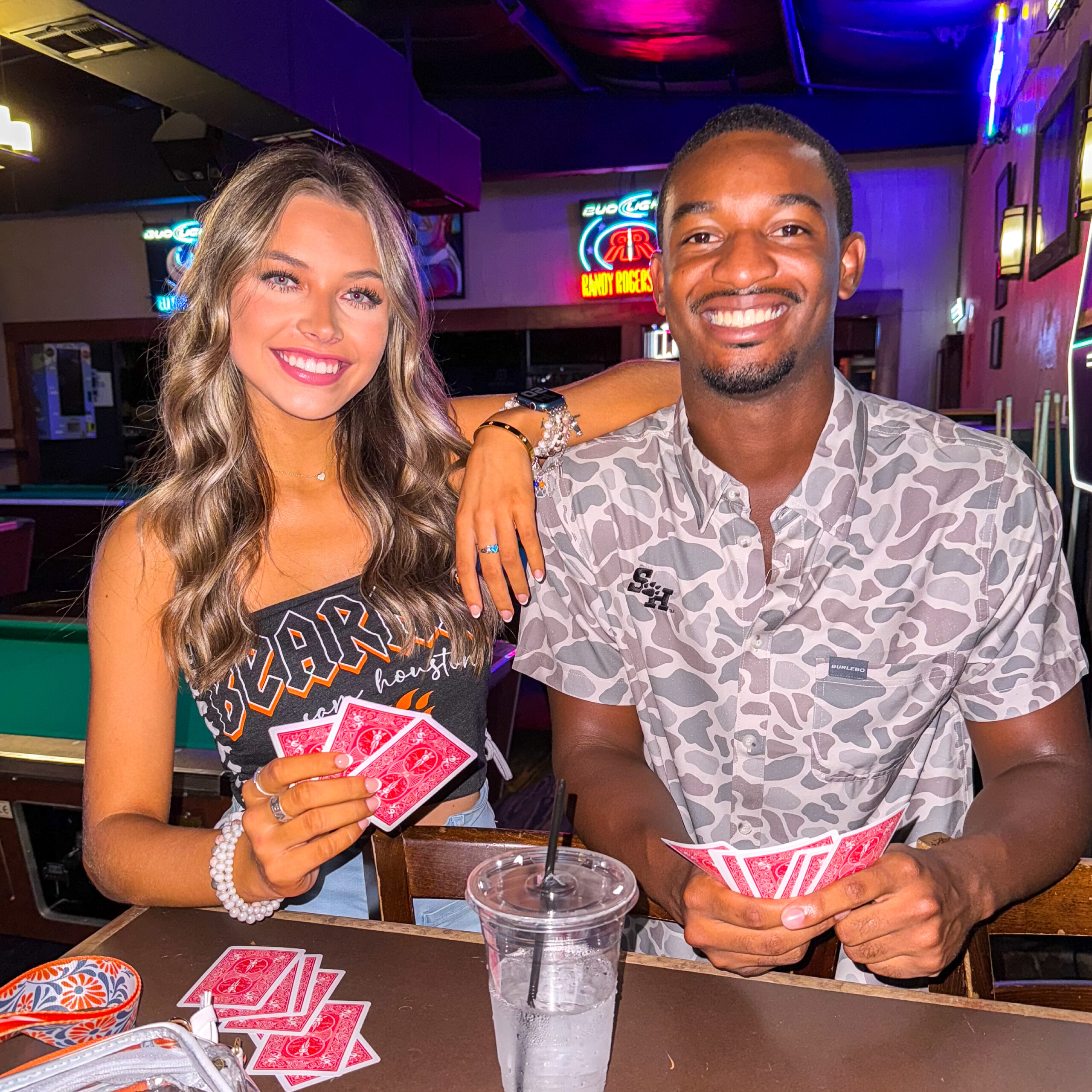 Two people playing cards in Sam Houston State apparel